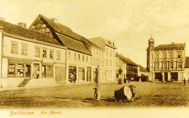 Ein altes Foto eines Stadtplatzes in Berlin, Deutschland, mit Gebäuden, Menschen und diversen Gegenständen im Vordergrund und einem bewölkten Himmel im Hintergrund, mit Text unten, der 'Berlinen am Markt' lautet.