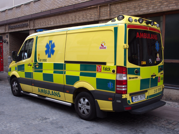 Ambulanz vor einem Backsteingebäude mit Text geparkt, mit Feuerlöscher auf der linken Seite.