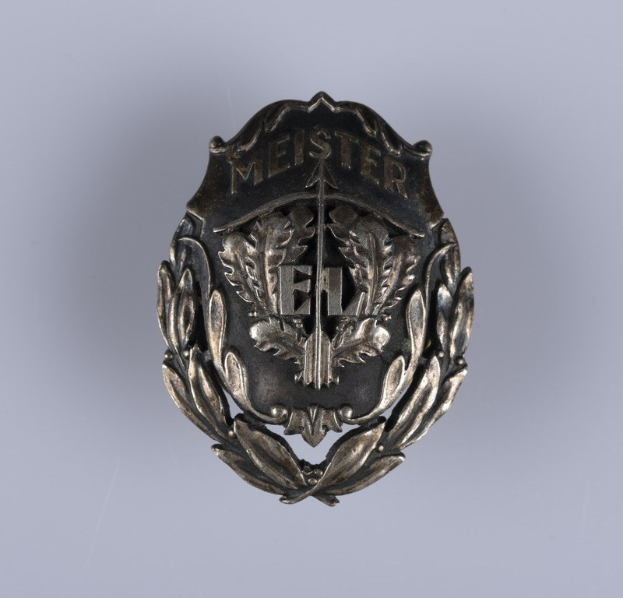 Silbernes deutsches Armeeabzeichen mit Lorbeerkranz und mittig plazierter Beschriftung.