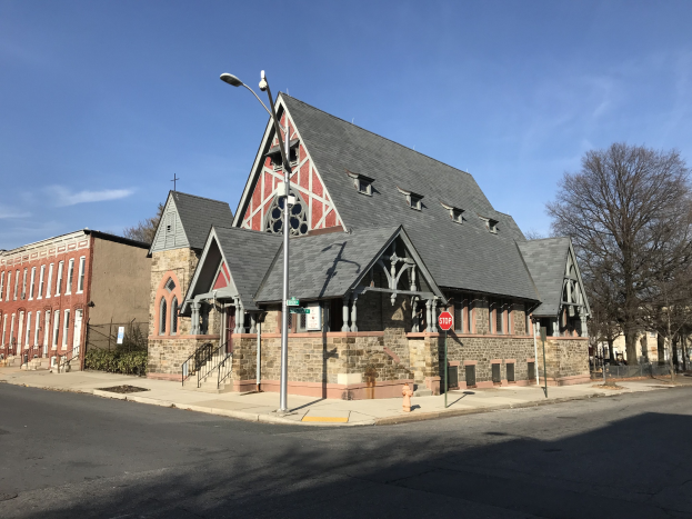 Alte Kirche an einer Straßenecke in St. Louis, Missouri, umgeben von Gebäuden, Straßenmöbeln, Fahrzeugen, Grünflächen und einem bewölkten Himmel.