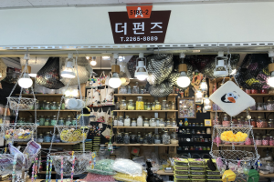 Ein Geschäft mit verschiedenen Artikeln wie Körben, Lampen, Flaschen und Spielzeugen auf Regalen, mit einem Schild oben, das es als eines der besten koreanischen Geschäfte in Seoul ausweist.
