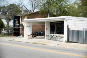 Ein Restaurant am Straßenrand mit Bäumen im Hintergrund.