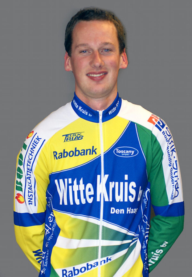Ein Sportler, der für ein Foto posiert und ein T-Shirt mit verschiedenen Sponsorennamen trägt.