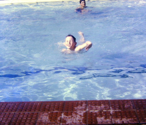 Zwei Kinder schwimmen in einem wassergefüllten Pool.