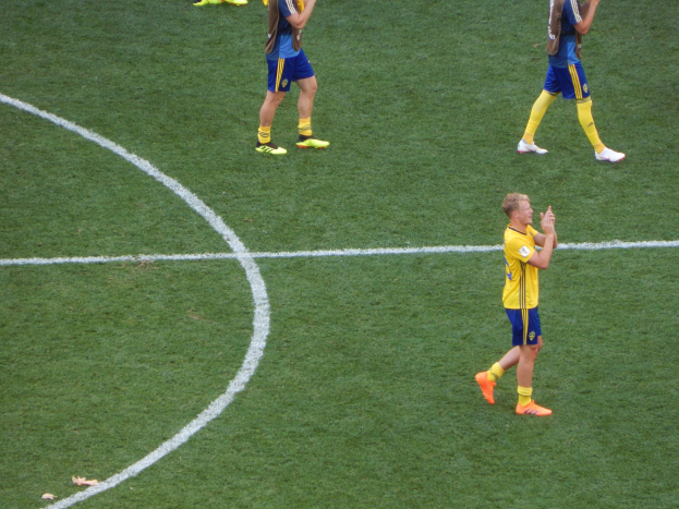 Mannergruppe in Fußballtrikots klatscht auf einem Fußballfeld