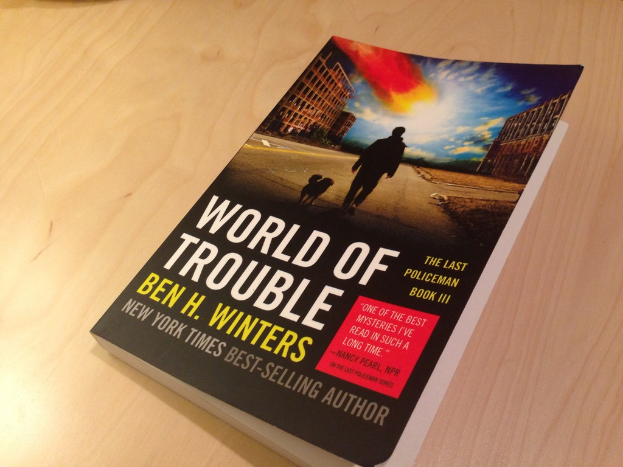 Ein Buch mit dem Titel "Welt der Probleme" mit einem Bild eines Mannes und eines Hundes auf einem Tisch.