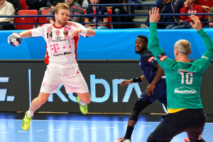 Männer bei einem Handballspiel auf einem Feld während des Futsal-Weltmeisterschafts 2019 zwischen Bayern München und Paris Saint-Germain, mit Zuschauern im Hintergrund.