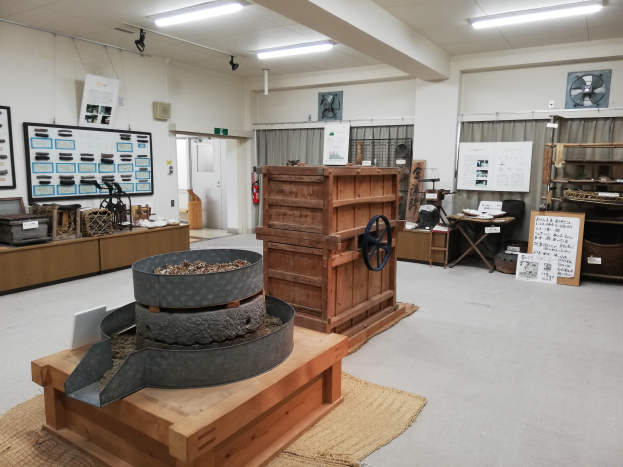 Eine Werkstatt im Nationalen Naturhistorischen Museum voller verschiedener Maschinen, Tische, Regale, einen Feuerlöscher und andere Gegenstände, mit einem Teppichboden, Vorhängen und einer Decke mit Lampen.